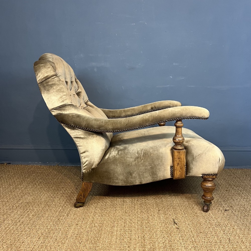 A late 19th-century Victorian open armchair with olive green velvet deep-buttoned upholstery, turned oak legs, and brass castors. View III