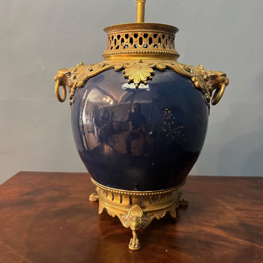 A 19th-century cobalt blue Chinese porcelain vase featuring gilt bronze ormolu mounts, lion mask handles, and a pierced collar.