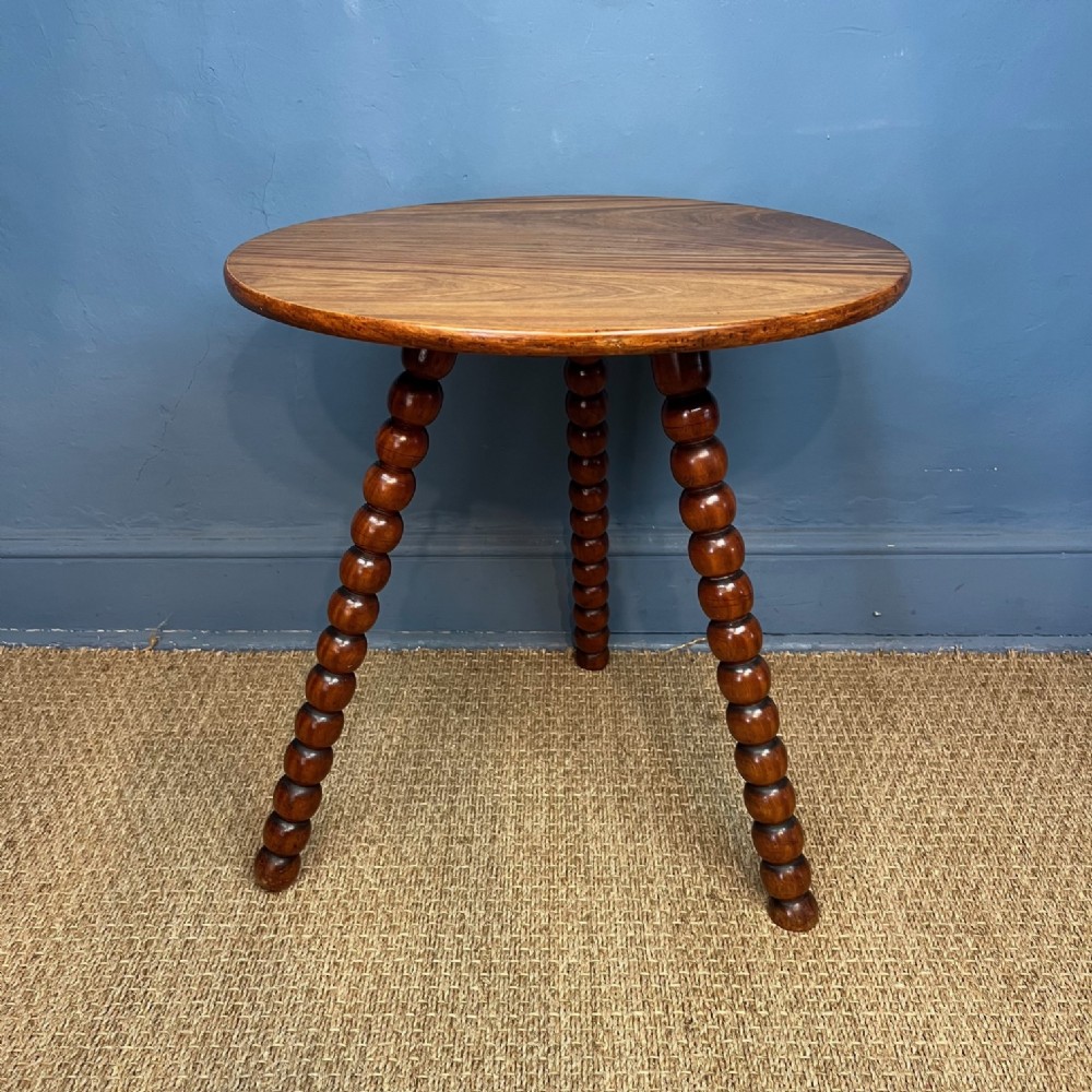 A late 19th-century Anglo-Indian circular gypsy table featuring a polished satinwood top and three bobbin-turned splayed legs.