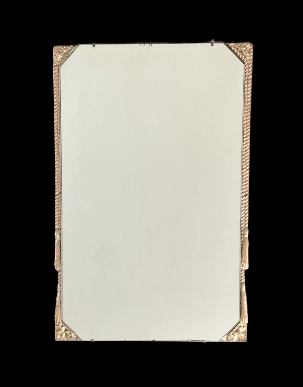 A rectangular Art Deco wall mirror featuring canted corners, a rope twist gilt border, and carved corner accents.