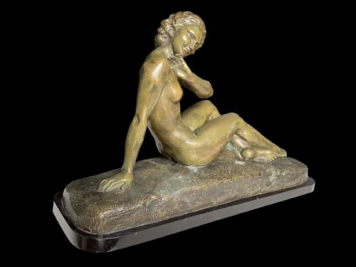 fig 1. An Art Deco bronze sculpture depicting a reclining female nude figure set on a moulded naturalistic base.