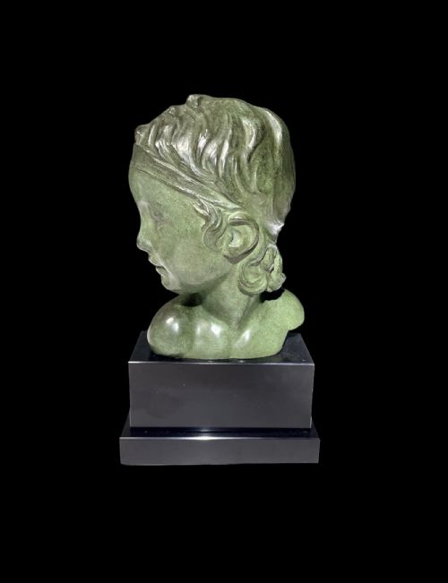 fig 1. An Art Deco patinated green bronze profile bust of a child, mounted on a polished black rectangular marble base.