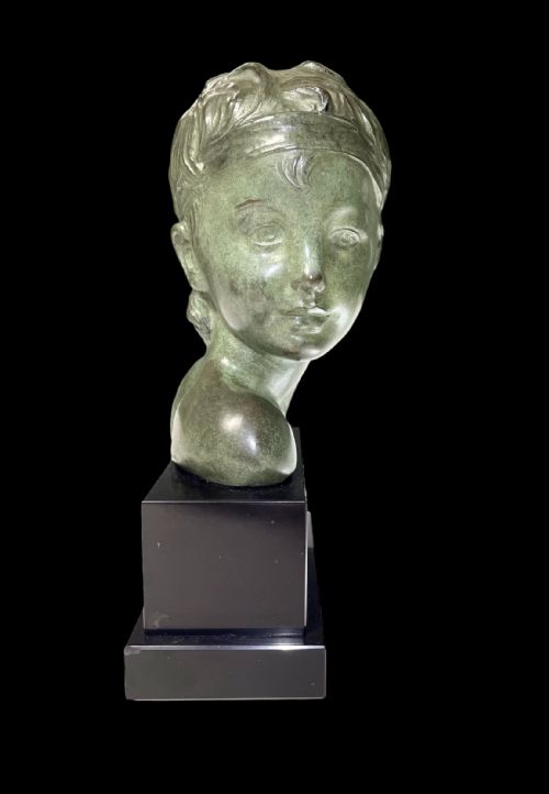 fig 2. An Art Deco patinated green bronze profile bust of a child, mounted on a polished black rectangular marble base.