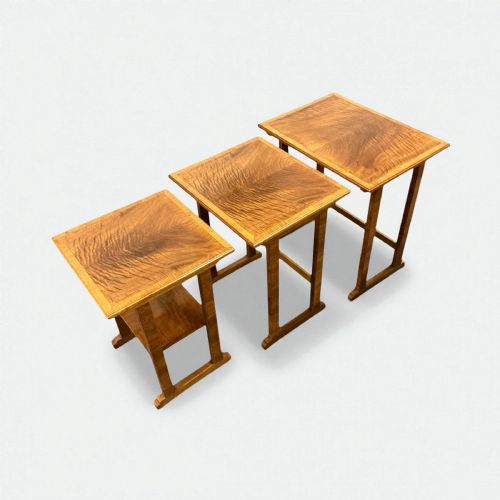fig 1. A set of three graduated Art Deco nesting side tables crafted from figured warm brown wood with crossbanded top borders.