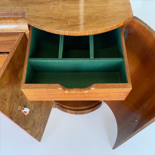 fig 1. An Art Deco burr walnut sideboard featuring sweeping curved ends, four cabinet doors with stylized handles, and a continuous plinth base.