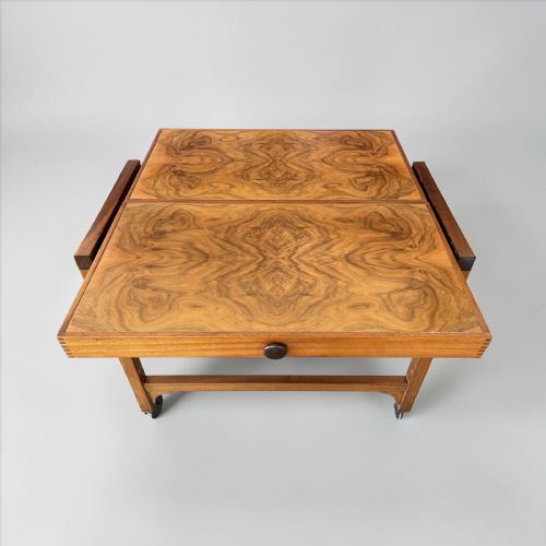 fig 1. An Art Deco two-tiered metamorphic serving trolley crafted from figured walnut veneer with dark trim and small swivel castors.