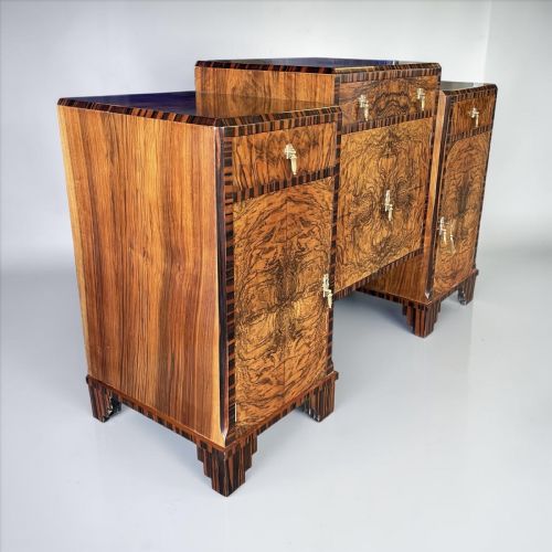 fig 1. An Art Deco sideboard crafted from rich burr walnut with dark striped wood borders, stepped base feet, and decorative brass drop handles.