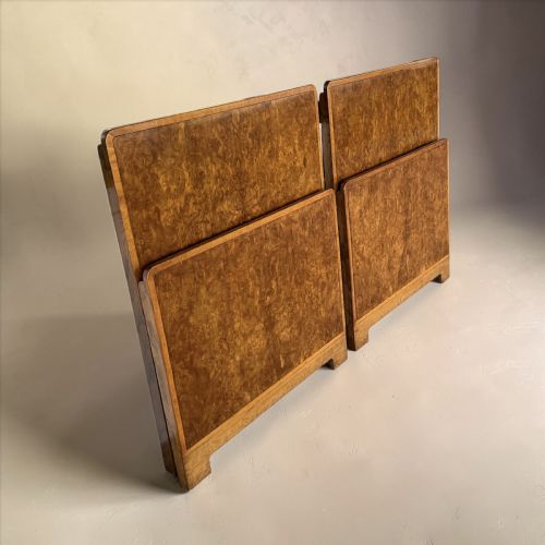 fig 1. A pair of disassembled Art Deco single bed frames crafted in rich burr walnut, showing headboards, footboards, iron side rails, and wooden slats.