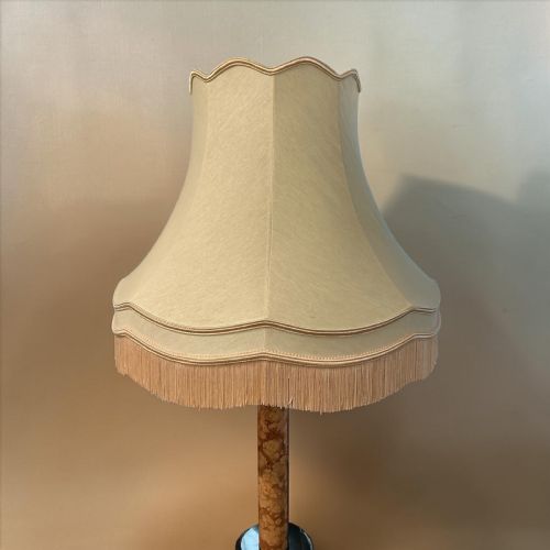 fig 1. An Art Deco standard lamp constructed from turned brown and black marble, featuring a circular integrated tray table, a stepped base, and a fabric fringed shade.