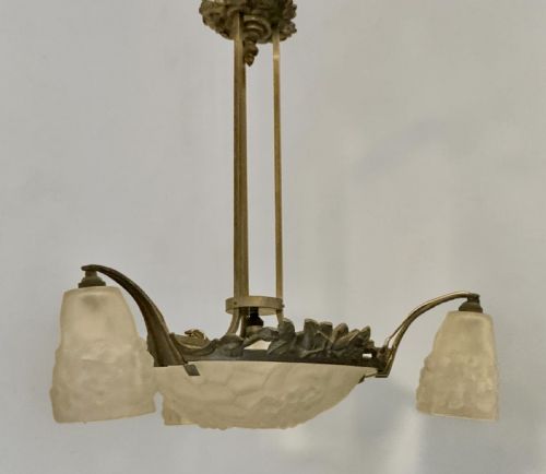 fig 2. An Art Deco ceiling light featuring a central moulded frosted glass bowl and matching outer shades supported by an ornate bronze mount.
