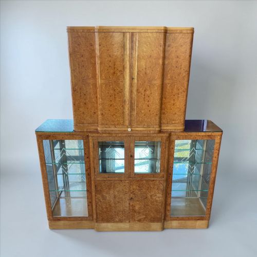 fig 1. An Art Deco burr walnut cocktail cabinet with open upper doors revealing a mirrored interior, flanked by lower etched glass display sections.