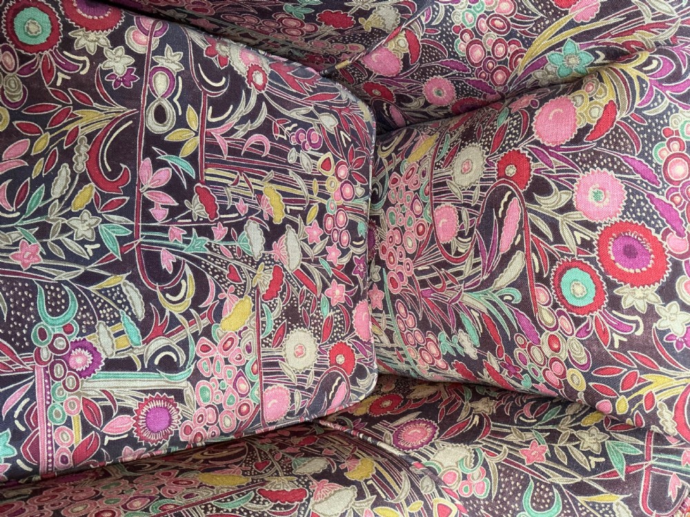 A pair of 1930s Art Deco armchairs featuring polished wood veneered side panels and vibrant floral patterned fabric upholstery. View XIII