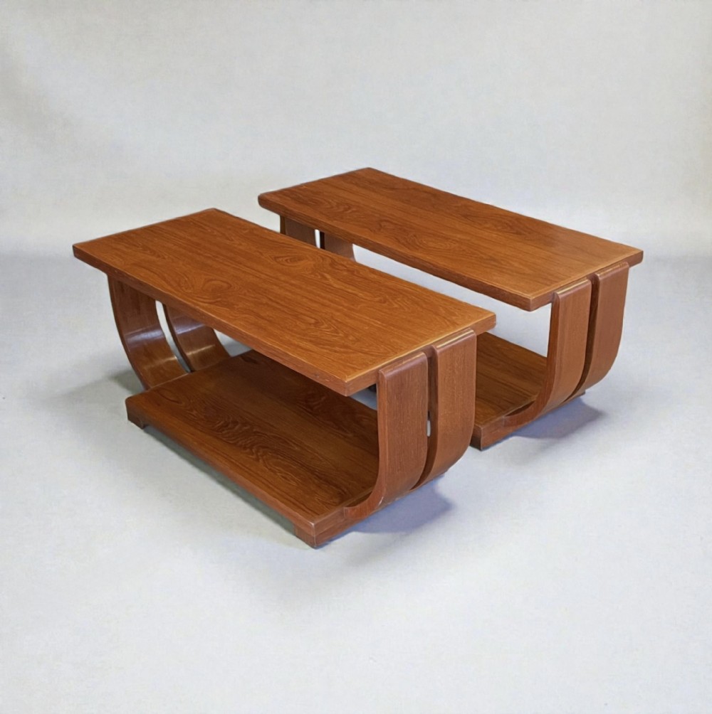 A pair of matching warm brown Art Deco timber side tables featuring curved bentwood legs and lower shelves.
