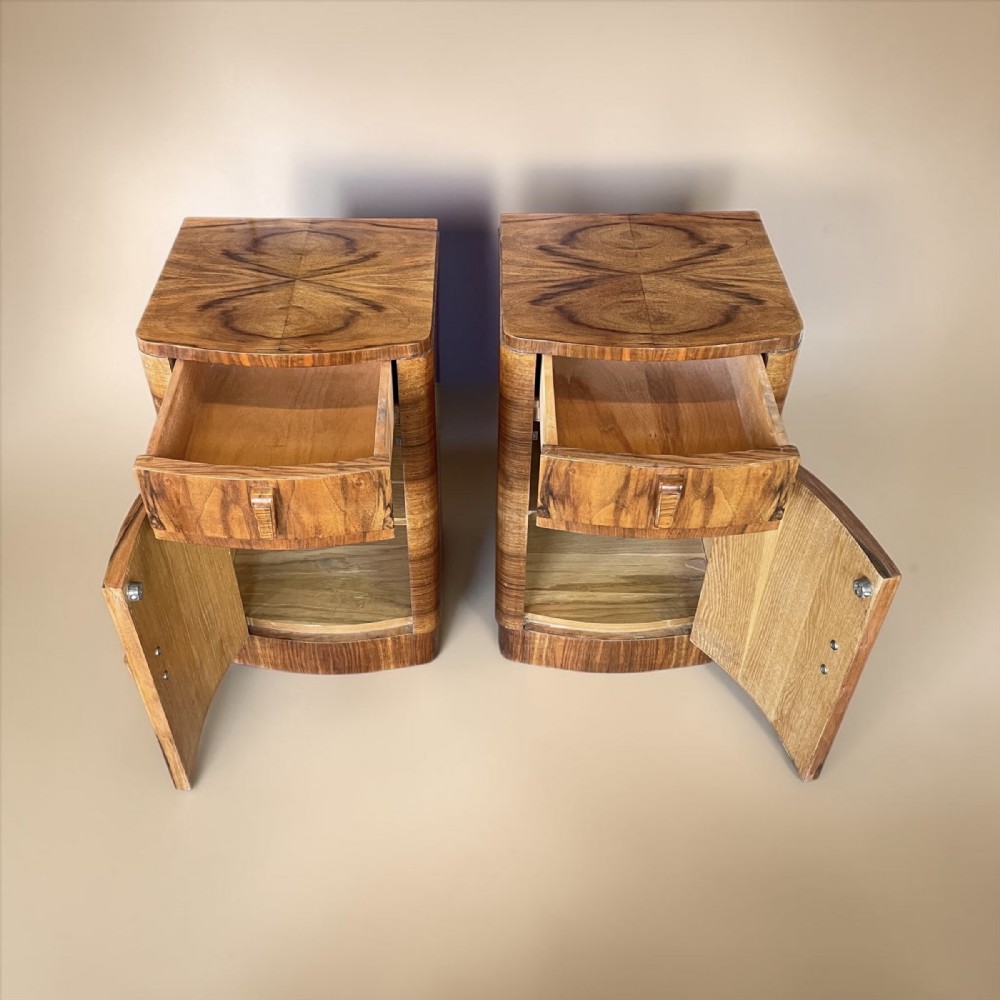 A matching pair of Art Deco walnut bedside cabinets featuring book-matched wood grain, single top drawers, rounded sides, and lower cupboard doors. View III