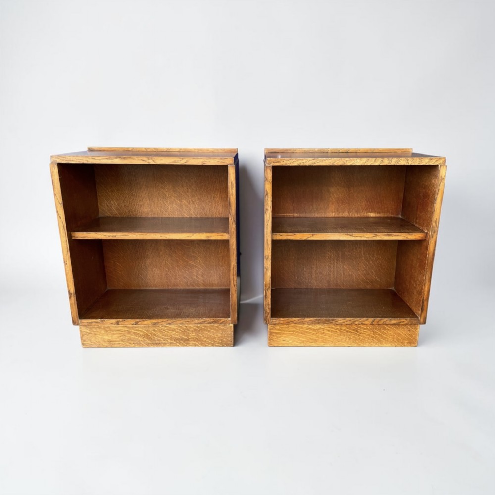 A matching pair of low, open oak bookcases featuring single fixed shelves and low gallery edges at the top.