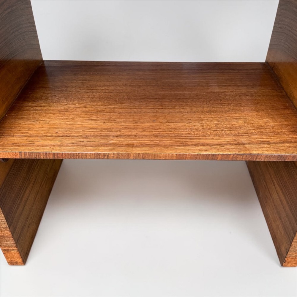 A circular Art Deco coffee table made of figured walnut veneer with a quartered top pattern, curved side supports, and an lower shelf. View VI