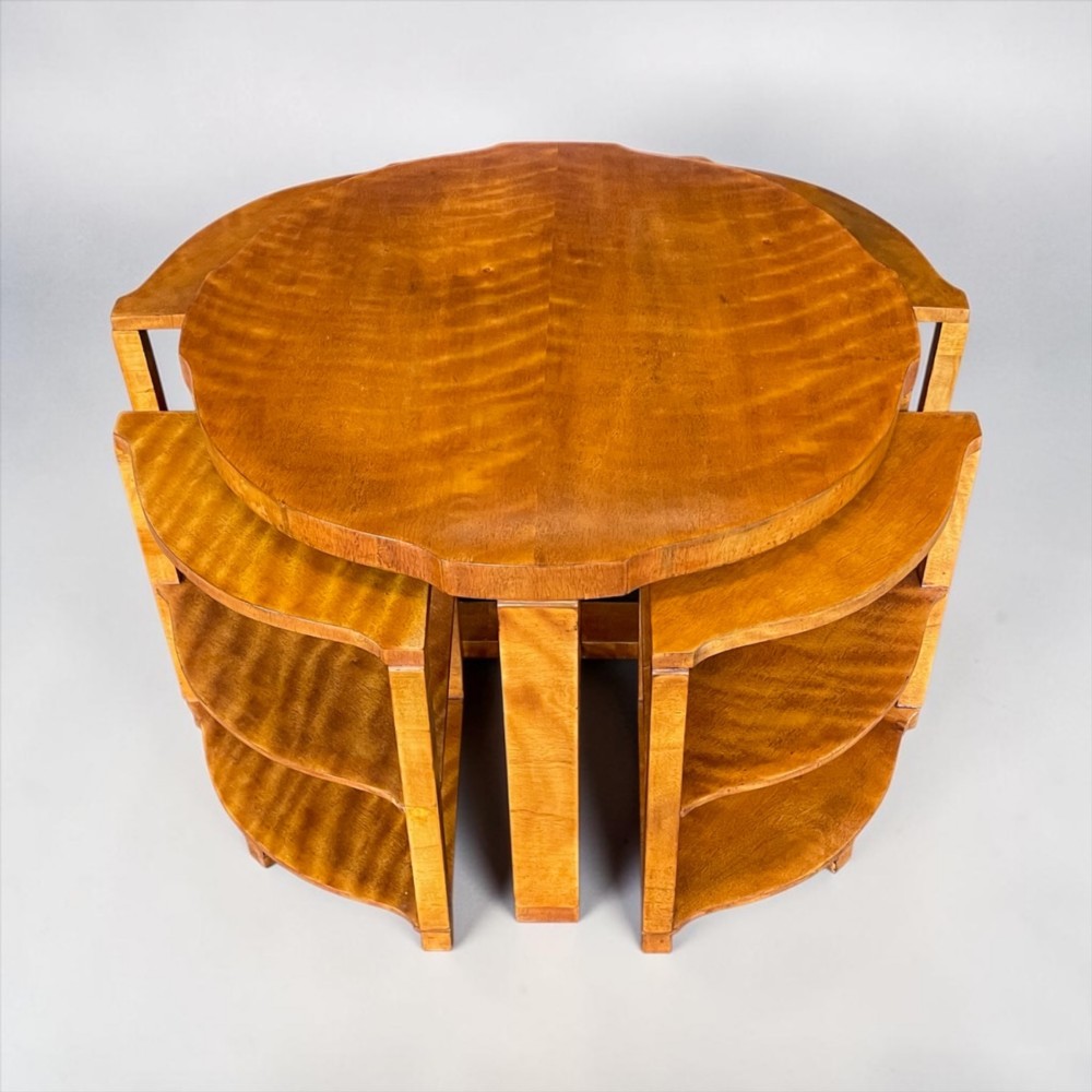 An Art Deco golden timber nest of five tables consisting of a central circular table encircled by four matching tiered wedge tables. View II