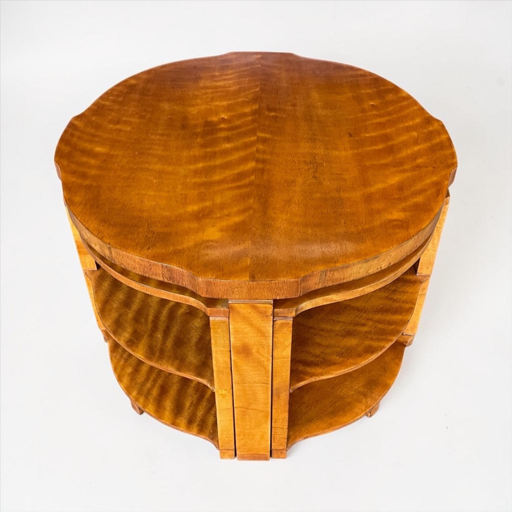 An Art Deco golden timber nest of five tables consisting of a central circular table encircled by four matching tiered wedge tables. View VI