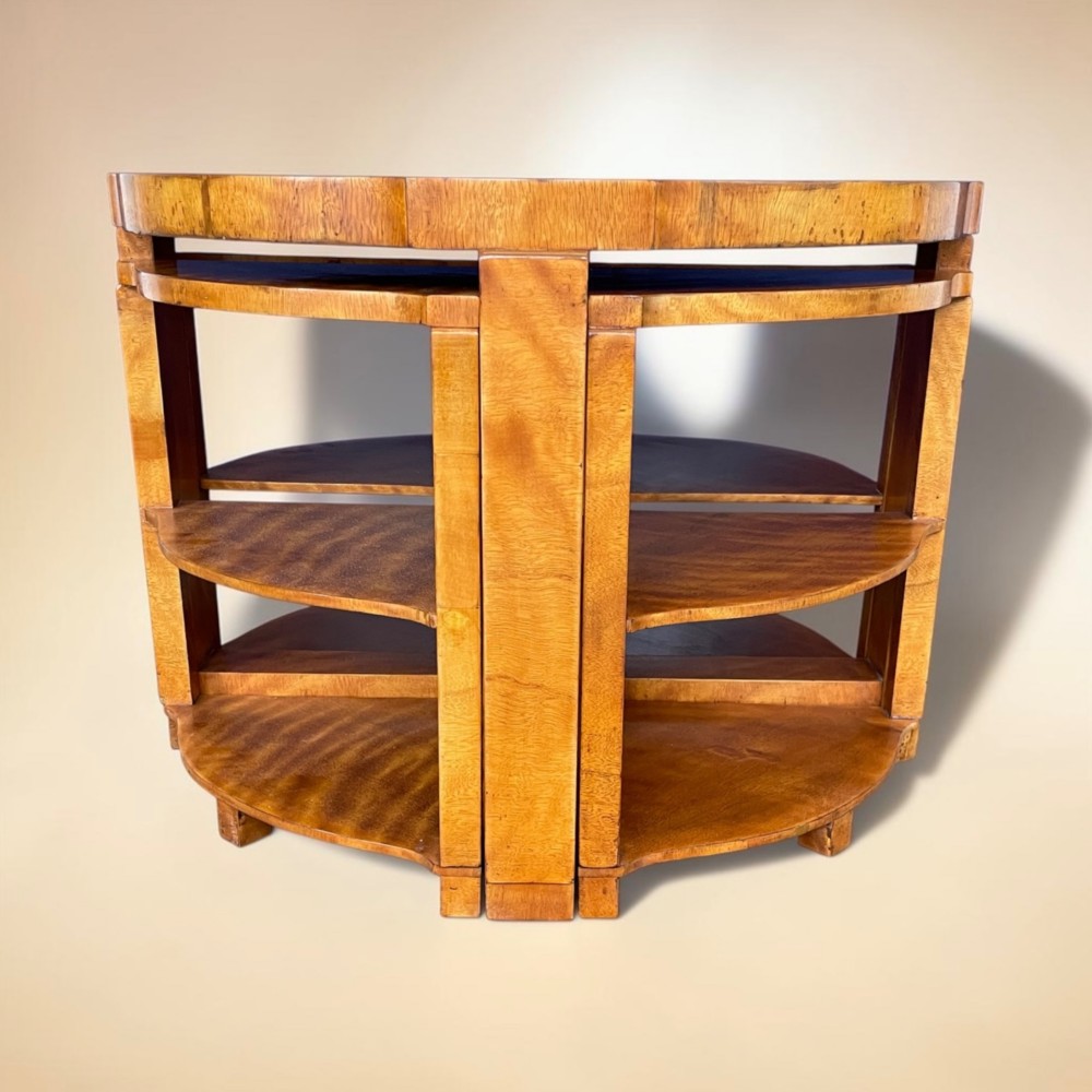 An Art Deco golden timber nest of five tables consisting of a central circular table encircled by four matching tiered wedge tables. View VII