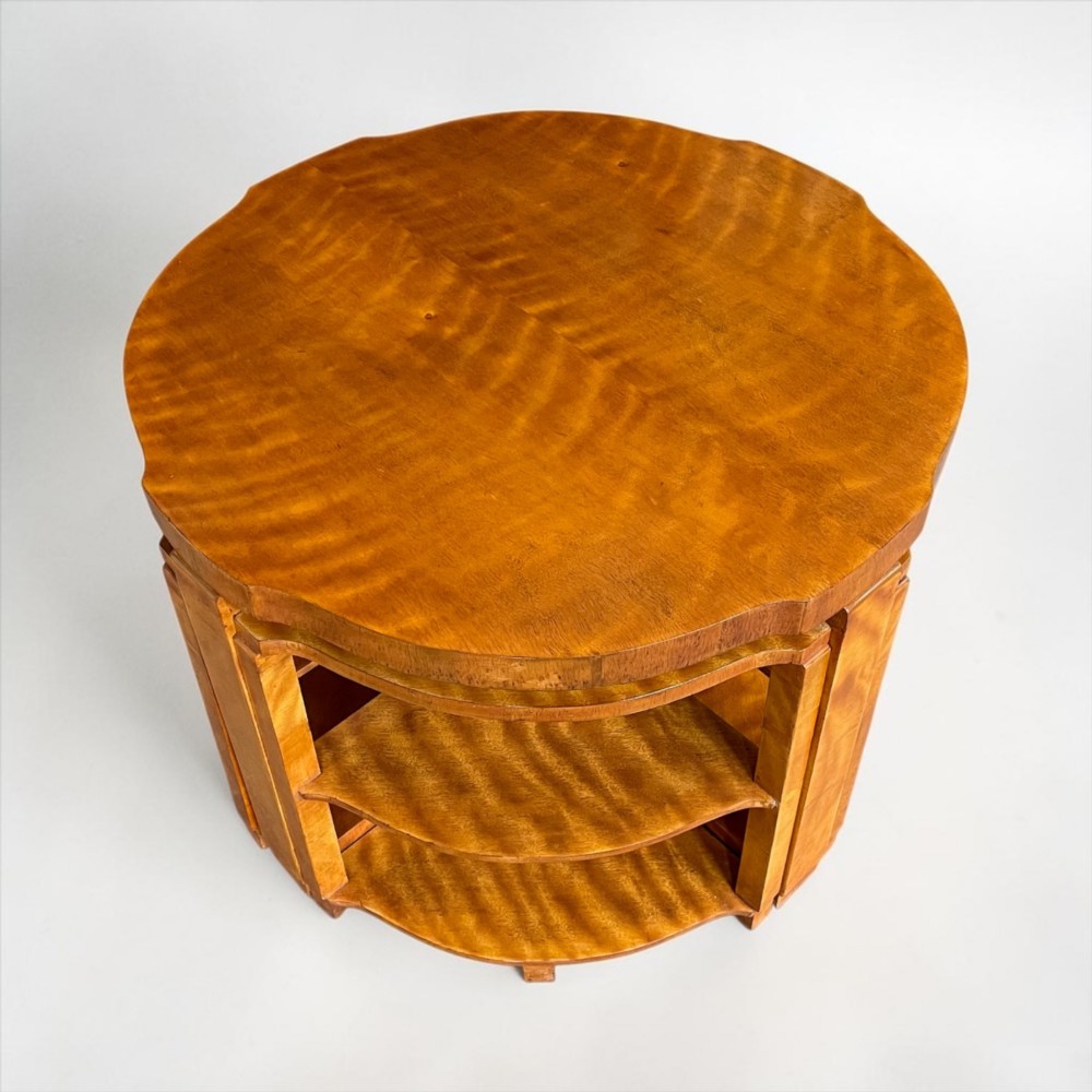 An Art Deco golden timber nest of five tables consisting of a central circular table encircled by four matching tiered wedge tables. View X