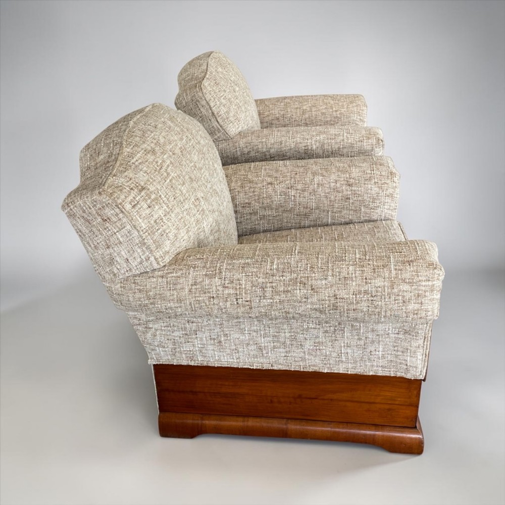 A pair of Art Deco lounge chairs featuring light beige textured upholstery and angular walnut bases. View IV