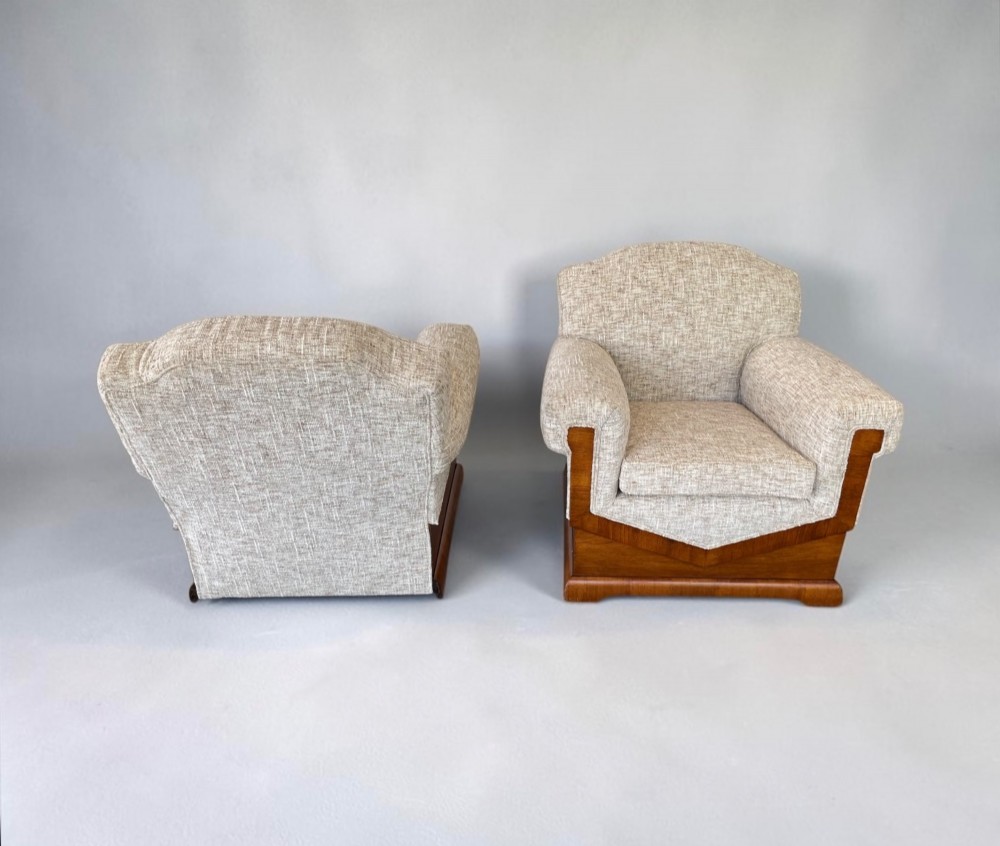 A pair of Art Deco lounge chairs featuring light beige textured upholstery and angular walnut bases. View VII