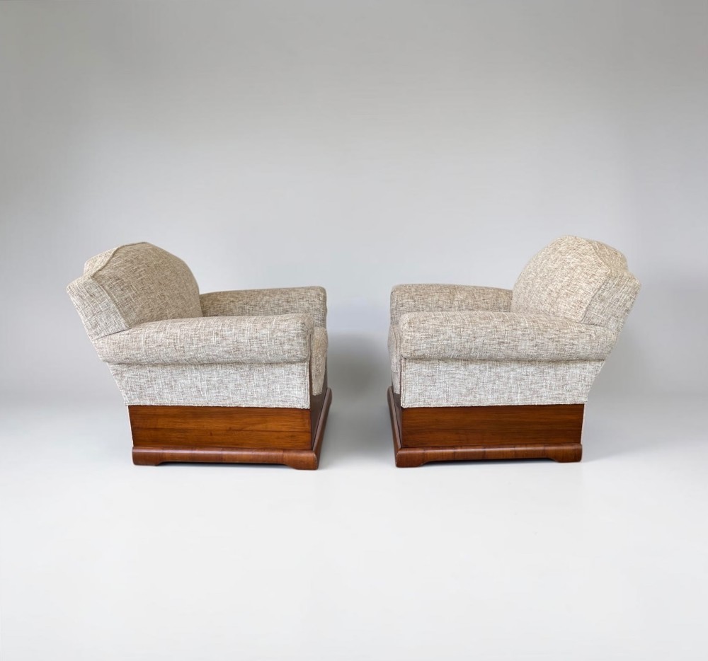 A pair of Art Deco lounge chairs featuring light beige textured upholstery and angular walnut bases. View IX
