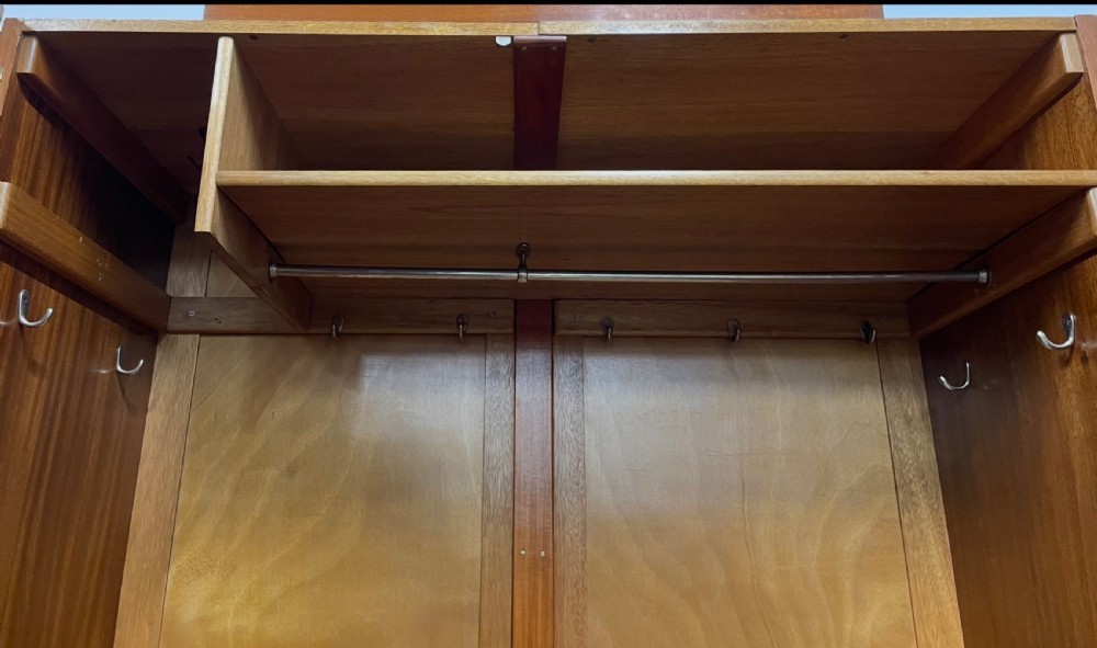An Art Deco double wardrobe crafted with figured light wood veneer featuring a stepped top profile and central vertical handles. View IV