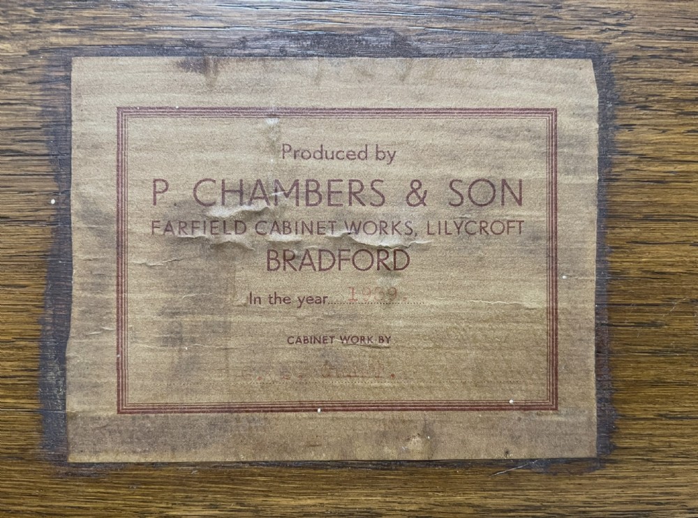 A pair of disassembled Art Deco single bed frames crafted in rich burr walnut, showing headboards, footboards, iron side rails, and wooden slats. View VI