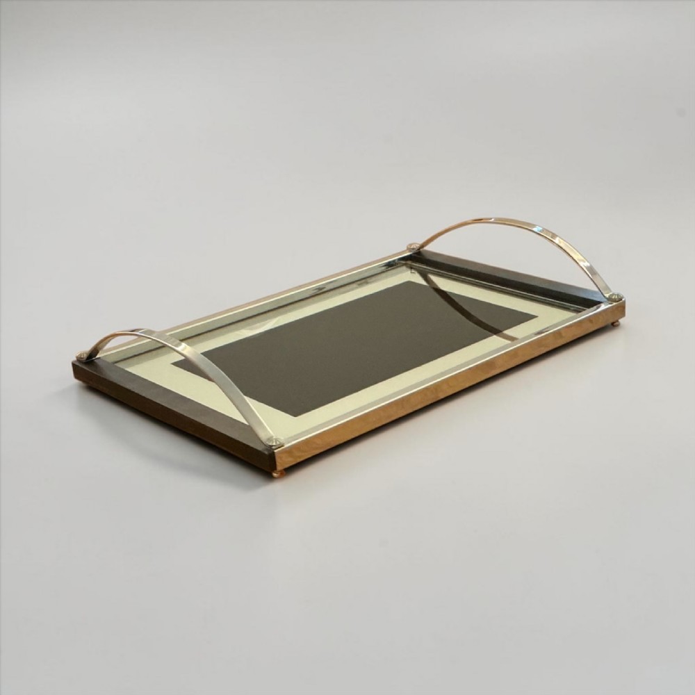 A rectangular Art Deco serving tray featuring dark wood side panels, a double-framed glass surface, and arched metallic handles.