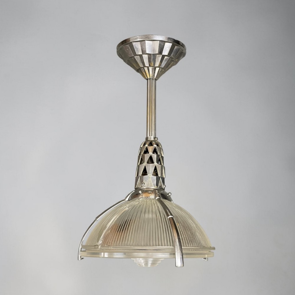 An Art Deco nickel-plated ceiling pendant light featuring a ribbed frosted glass shade suspended from a geometric stem and faceted canopy.