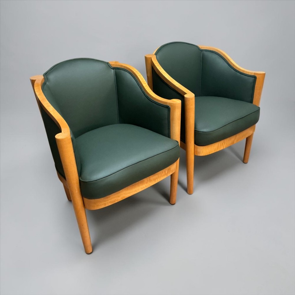 A pair of British Art Deco occasional chairs with curved light honey-toned timber frames and dark green leather upholstered seats and backrests. View IV