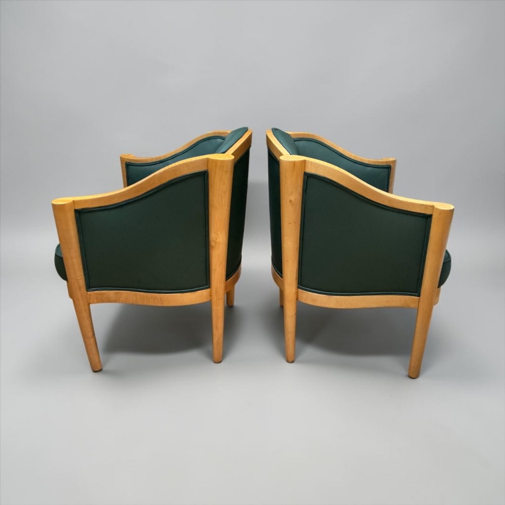 A pair of British Art Deco occasional chairs with curved light honey-toned timber frames and dark green leather upholstered seats and backrests. View VII