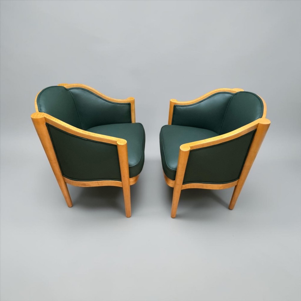 A pair of British Art Deco occasional chairs with curved light honey-toned timber frames and dark green leather upholstered seats and backrests. View VIII