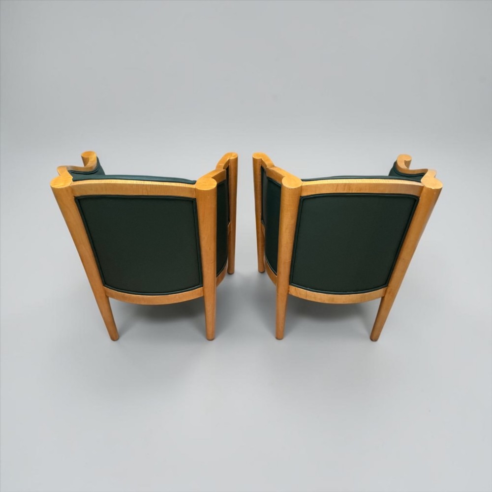 A pair of British Art Deco occasional chairs with curved light honey-toned timber frames and dark green leather upholstered seats and backrests. View IX