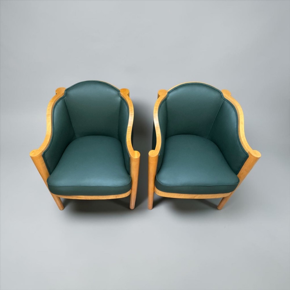 A pair of British Art Deco occasional chairs with curved light honey-toned timber frames and dark green leather upholstered seats and backrests. View XI
