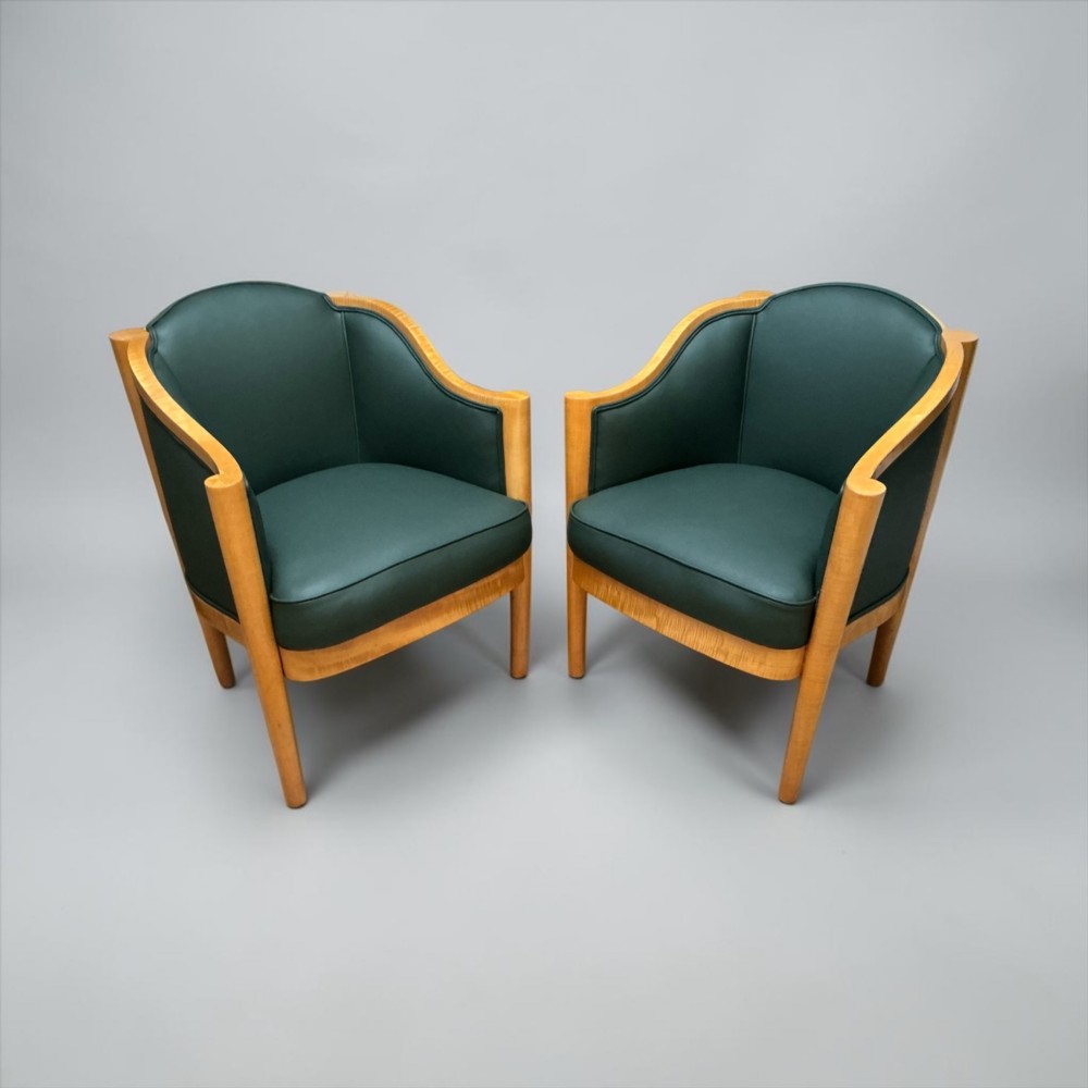 A pair of British Art Deco occasional chairs with curved light honey-toned timber frames and dark green leather upholstered seats and backrests. View XII