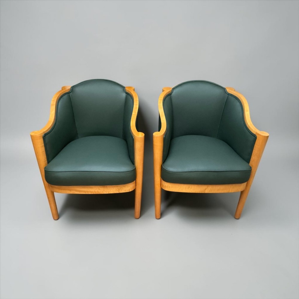 A pair of British Art Deco occasional chairs with curved light honey-toned timber frames and dark green leather upholstered seats and backrests. View XIII