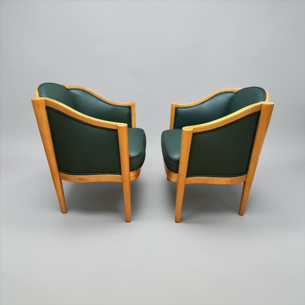 A pair of British Art Deco occasional chairs with curved light honey-toned timber frames and dark green leather upholstered seats and backrests. View XIV