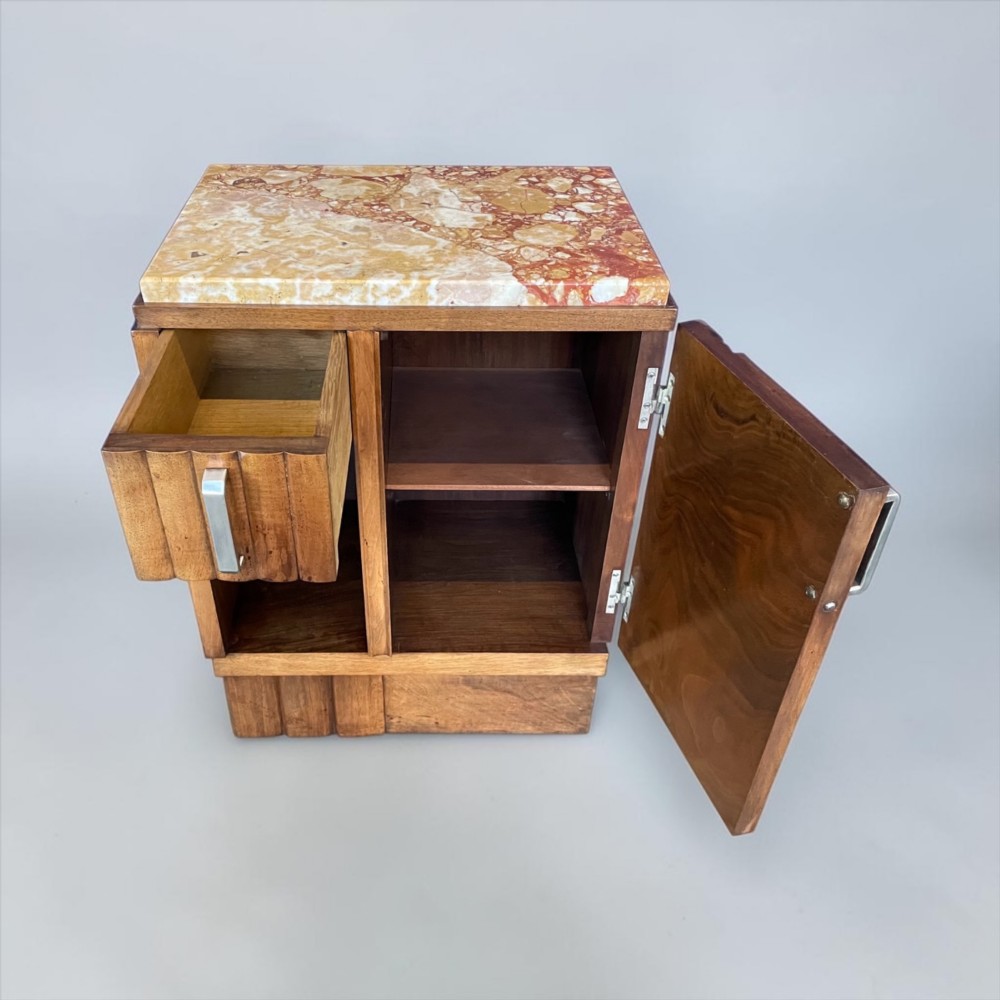 An Art Deco bedside cabinet crafted from polished brown walnut wood featuring a variegated reddish marble top surface and metal handles. View V