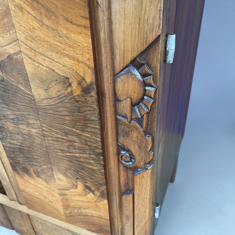 An Art Deco bedside cabinet crafted from polished brown walnut wood featuring a variegated reddish marble top surface and metal handles. View X