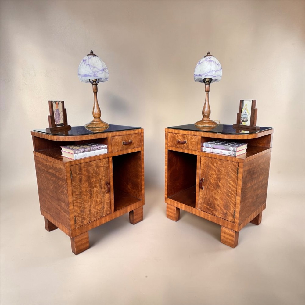 A pair of matching warm brown wooden Art Deco bedside cabinets with asymmetrical drawers, open shelves, lower cupboards, and block feet. View III
