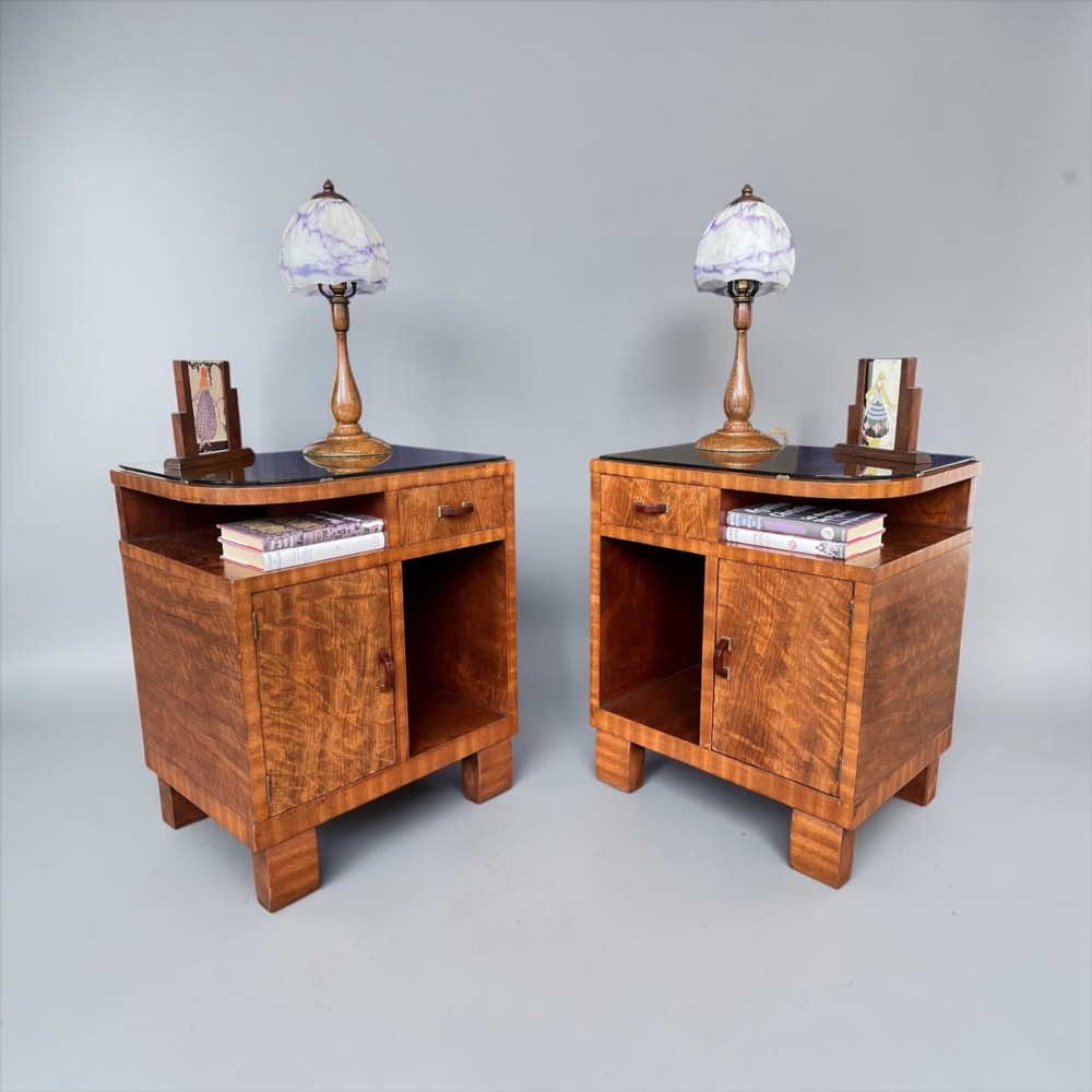 A pair of matching warm brown wooden Art Deco bedside cabinets with asymmetrical drawers, open shelves, lower cupboards, and block feet. View VII