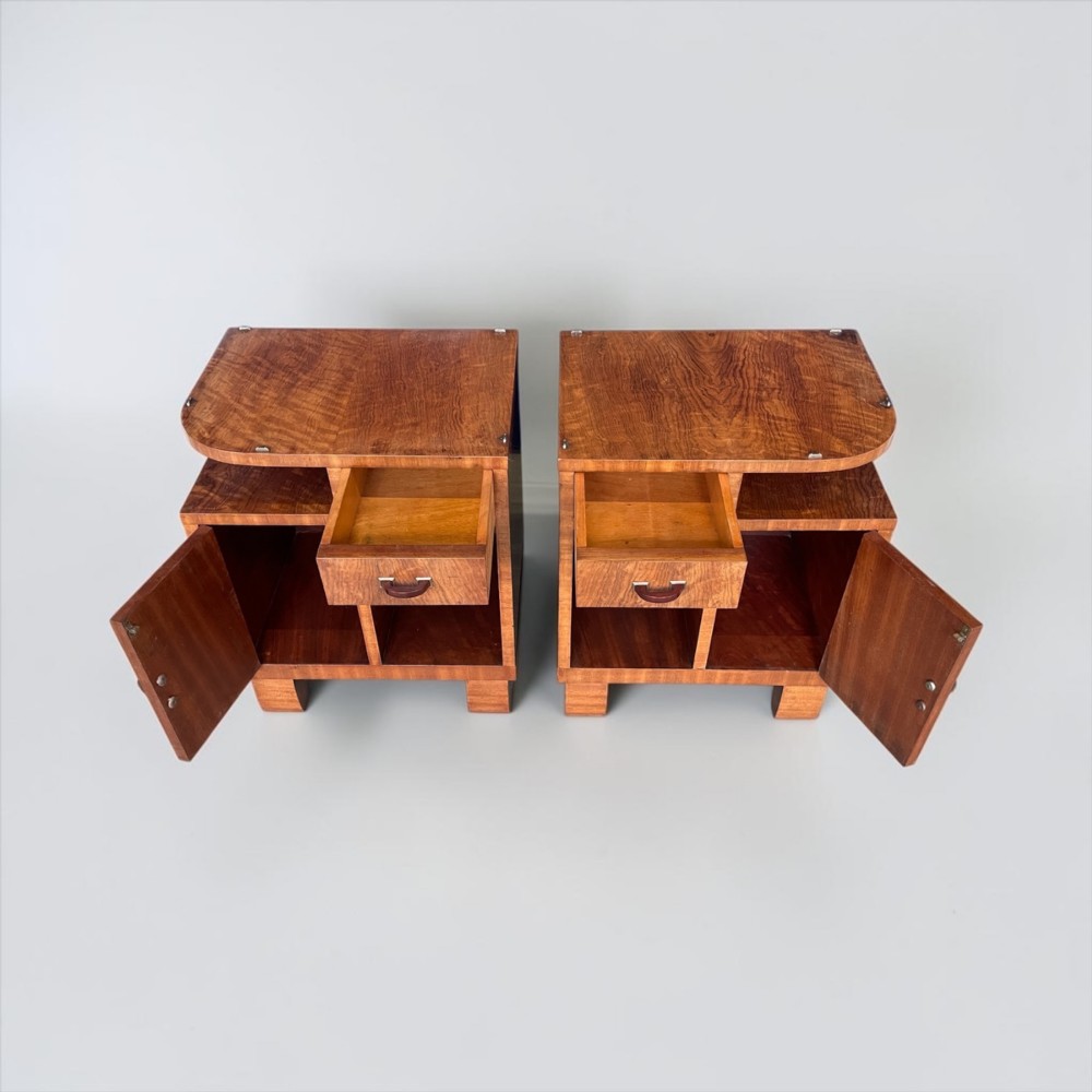 A pair of matching warm brown wooden Art Deco bedside cabinets with asymmetrical drawers, open shelves, lower cupboards, and block feet. View XI