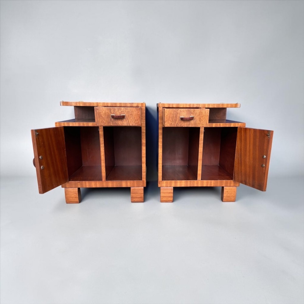 A pair of matching warm brown wooden Art Deco bedside cabinets with asymmetrical drawers, open shelves, lower cupboards, and block feet. View XII
