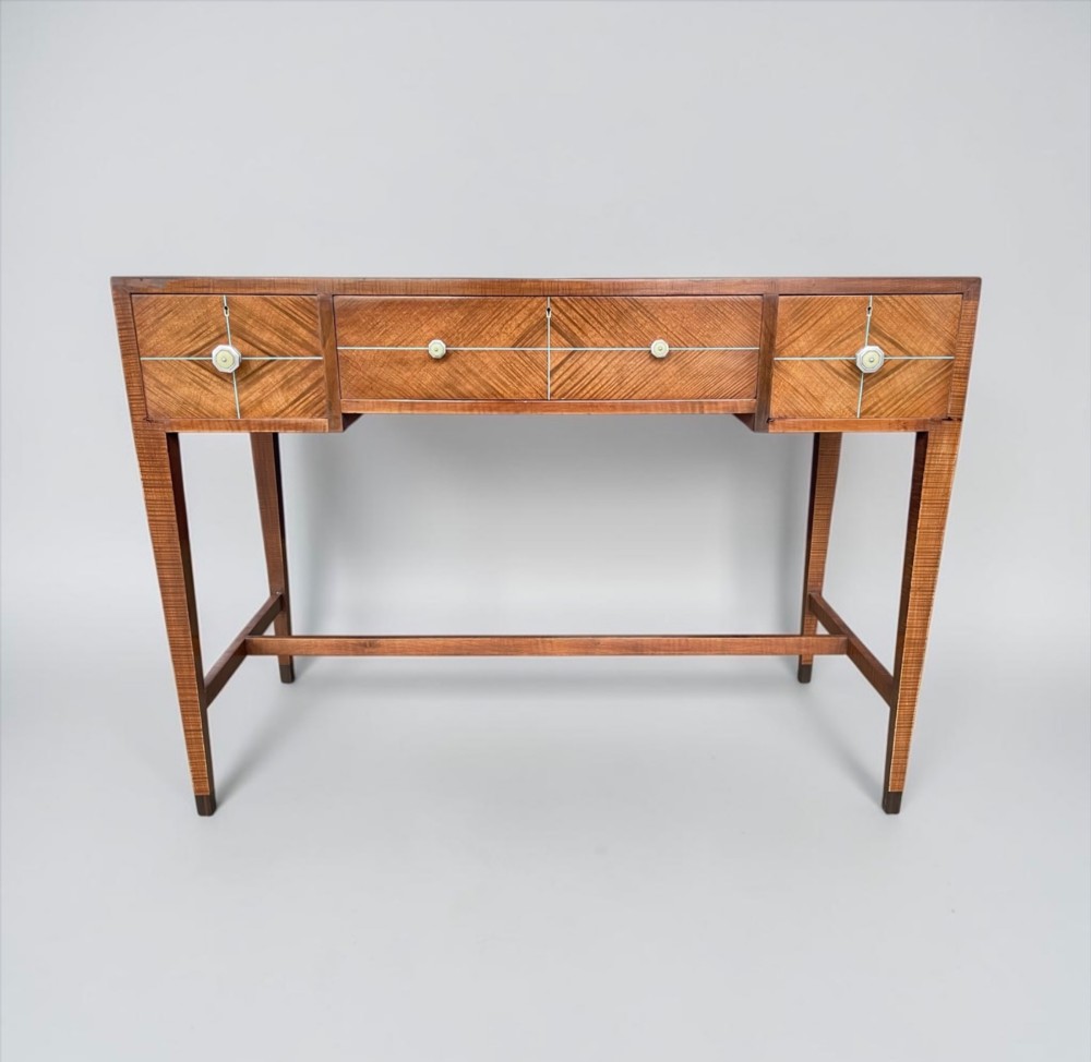 An Art Deco writing desk with geometric chevron parquetry drawer fronts, fine line inlay, and octagonal pulls on slender tapered legs. View II