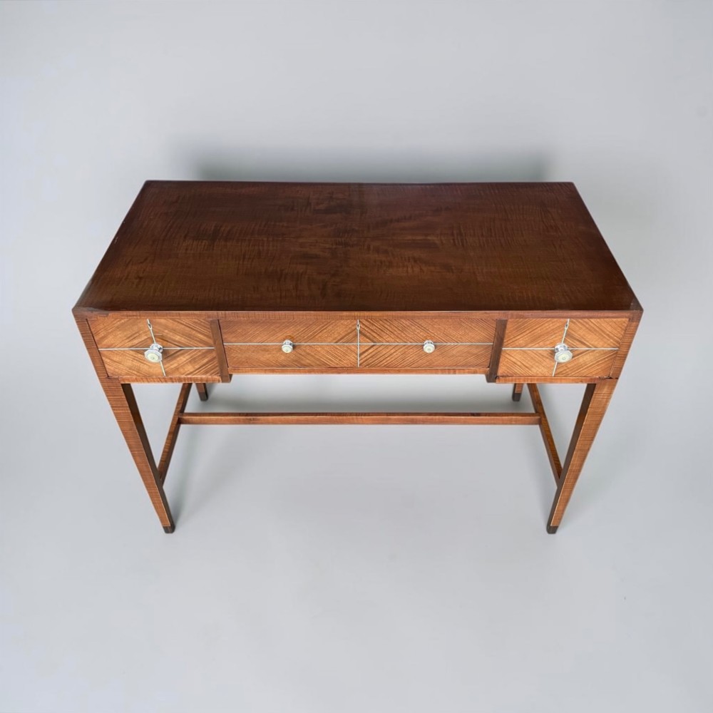 An Art Deco writing desk with geometric chevron parquetry drawer fronts, fine line inlay, and octagonal pulls on slender tapered legs. View III