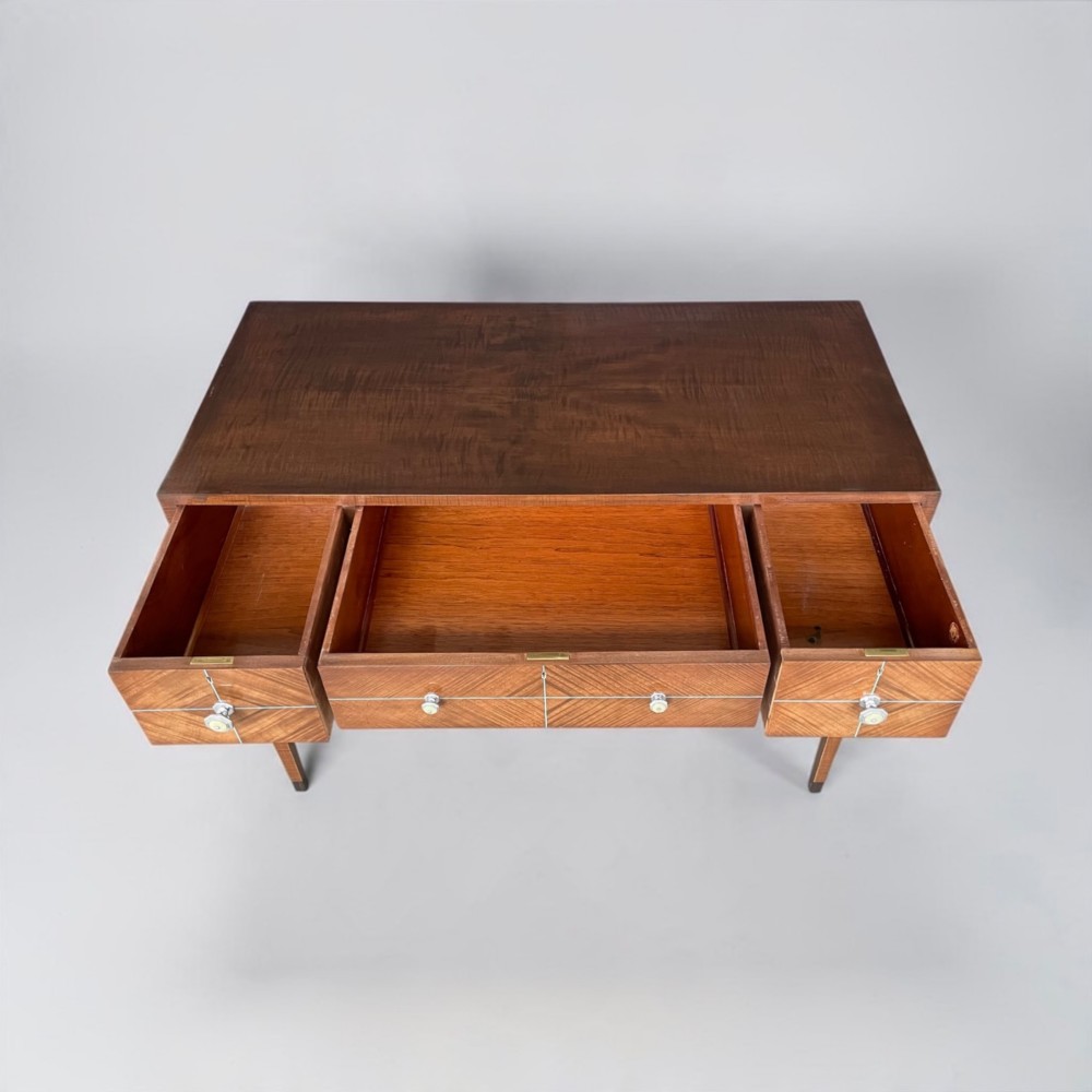 An Art Deco writing desk with geometric chevron parquetry drawer fronts, fine line inlay, and octagonal pulls on slender tapered legs. View IV