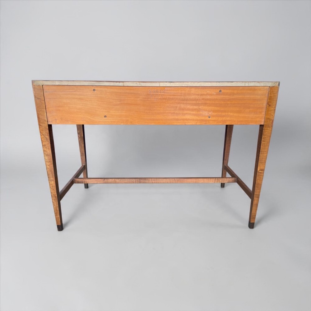 An Art Deco writing desk with geometric chevron parquetry drawer fronts, fine line inlay, and octagonal pulls on slender tapered legs. View IX