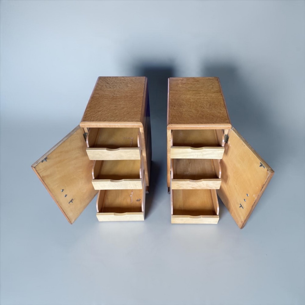 A matching pair of golden burr maple Art Deco bedside tables featuring single door cupboards with wooden block handles and plinth bases. View III